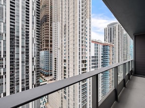 A high-rise building with multiple floors, large windows, and a balcony. - 501 First #2506 Skyline Essence Living (Miami)