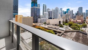 Un paisaje urbano con rascacielos, edificios modernos, una grúa de construcción y un cielo despejado.
