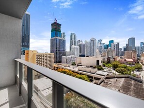 Horizontale Skyline mit Hochhäusern, einem Baukran und blauem Himmel.