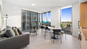 Un apartamento moderno con balcón, comedor y vistas a la ciudad.