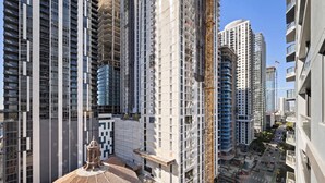 Ein Hochhaus mit mehreren Stockwerken, einem Baukran und einer belebten Straße darunter.