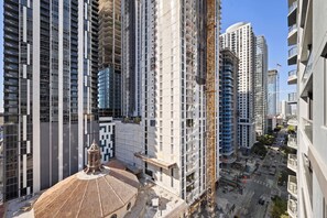 Ein Hochhaus mit mehreren Stockwerken, einem Baukran und einer belebten Straße darunter.