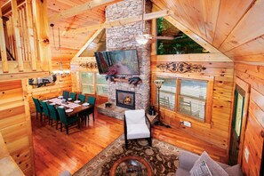 A cozy cabin interior with a dining area, fireplace, and large windows. - Black Beary Lodge・Hot Tub・Pool Table・Community Pool・Arcade (Gatlinburg)