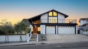 A two-story house with a front porch, a garage, and a balcony. - Skyline Palms by Avantstay Pool + 2 Hot Tubs + Outdoor Dining Near La Jolla + Pacific Beach (San Diego)