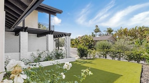 A modern house with a white brick exterior, a balcony, and a well-maintained lawn. - Skyline Palms by Avantstay Pool + 2 Hot Tubs + Outdoor Dining Near La Jolla + Pacific Beach (San Diego)