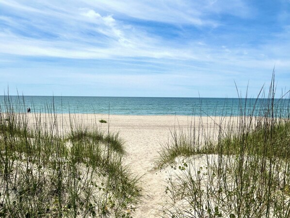 A beach with sand dunes and a clear view of the ocean. - 2BR Holden Beach condo with pool and pet-friendly. (Holden Beach)