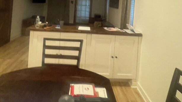 Een eethoek met een tafel, stoelen, een plafondventilator en een keuken op de achtergrond.