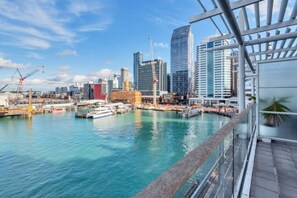 A waterfront cityscape with modern buildings, a marina with boats, and a clear sky. - Harbour Views Morning Sun on Iconic Princes Wharf (Auckland City)