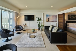 A modern living room with a flat-screen TV, leather sofas, a coffee table, and a large window. - Harbour Views Morning Sun on Iconic Princes Wharf (Auckland City)