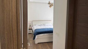 Ein Schlafzimmer mit Bett, Nachttisch und einer Pendelleuchte.