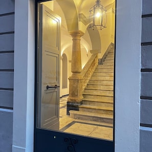 A grand staircase with marble steps and a wooden balustrade, leading to an upper floor.