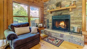 A cozy cabin interior with a stone fireplace, leather sofa, and large windows. - Bent Tree Cabin・Hot Tub・Game Room・Views + Scenic Binoculars (Jasper)
