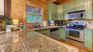A kitchen with granite countertops, stainless steel appliances, and green cabinets. - Bent Tree Cabin・Hot Tub・Game Room・Views + Scenic Binoculars (Jasper)