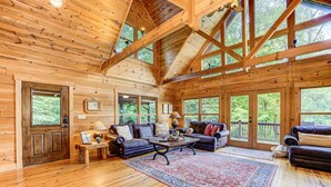 A log cabin interior with a wooden floor, a sofa, a coffee table, and large windows. - Bent Tree Cabin・Hot Tub・Game Room・Views + Scenic Binoculars (Jasper)