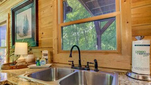 A kitchen with two stainless steel sinks, wooden walls, a window with a view of trees, and a green heritage paper towel dispenser. - Bent Tree Cabin・Hot Tub・Game Room・Views + Scenic Binoculars (Jasper)