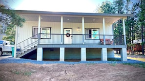 A two-story building with a covered porch and a staircase leading to the upper level.
