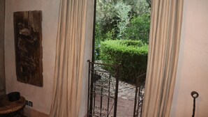 Um quarto com porta de madeira, portão de metal e caminho de pedra que leva para o exterior.