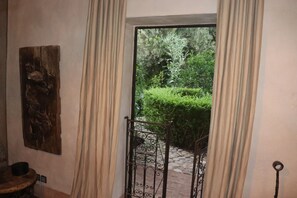 Une piĂšce dotĂ©e dâune porte en bois, dâun portail en mĂ©tal et dâun chemin de pierre menant Ă lâextĂ©rieur.