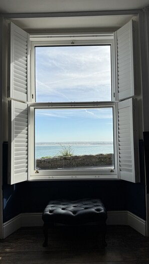 Ein Erker mit Meerblick und eine schwarze Ledobank in der Ecke.