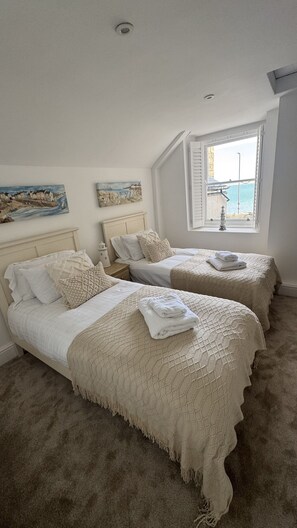 A bedroom with two beds, a window with shutters, and artwork on the walls. - Minster Panorama and Minster Vista Connected is a beautifully restored three story Georgian Town Hou (St Ives)