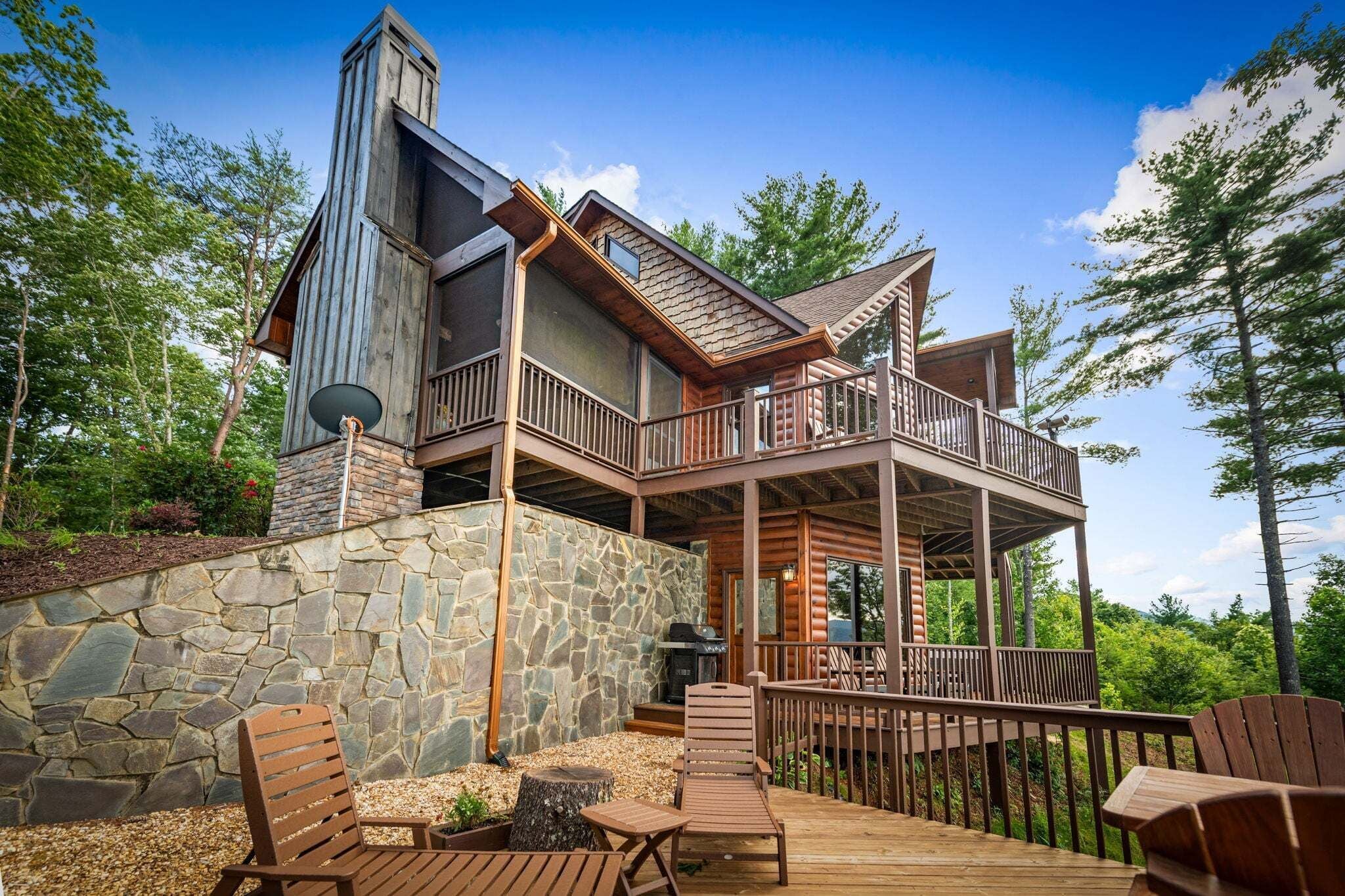 A cabin with a stone exterior, wooden deck, and multiple balconies.