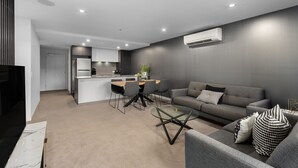A modern living space with a kitchen, dining area, and seating area. - Stylish City Apartment up to 6 guests with 5 Star amenities (Braddon)