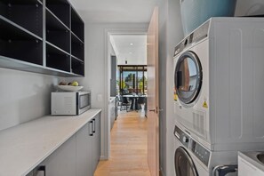 Ein kleiner Hauswirtschaftsraum mit Waschmaschine, Trockner und Mikrowelle.