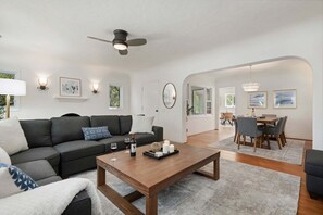 Ein modernes Wohnzimmer mit Sofa, Couchtisch und Essbereich.