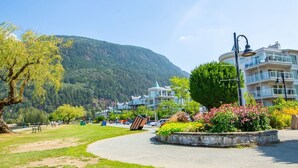 A park with a curved pathway, benches, and a roundabout with flowers.