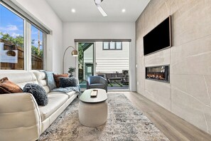A modern living room with a sofa, coffee table, and fireplace.