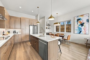 A modern kitchen with wooden cabinets, stainless steel appliances, and a central island.