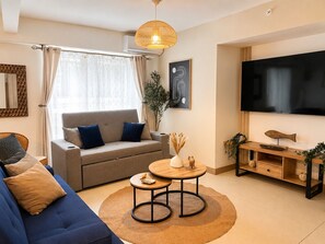 Ein modernes Wohnzimmer mit einer Couch, einem Couchtisch und einem Fernseher.