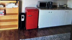 A kitchen with a microwave, a red appliance, and a wooden cabinet. - Linden Leaf Gasthaus Inn Apartment Pet friendly Country walks, just off hwy 416 (Oxford Station)