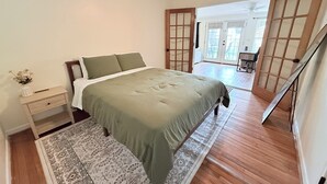 A bedroom with a bed, nightstand, and a view of the outside. - Home near DFW Airport & Arlington World Cup. Perfect for groups and families. (Irving)