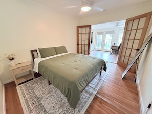 A bedroom with a bed, nightstand, and a view of the outside. - Home near DFW Airport & Arlington World Cup. Perfect for groups and families. (Irving)