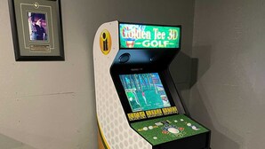Une borne d’arcade de golf en 3D, dotée d’une base en bois et d’un écran affichant un jeu de golf.