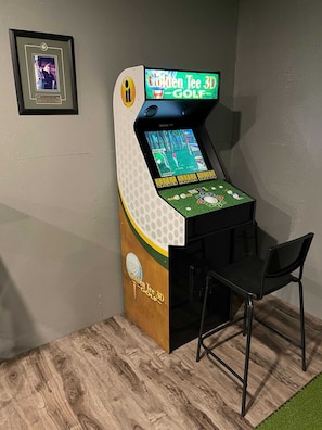 Een 3D golf-arcadekast met een houten basis en een scherm waarop een golfspel wordt weergegeven.