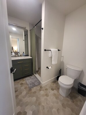 Un baño con inodoro, ducha y lavamanos.