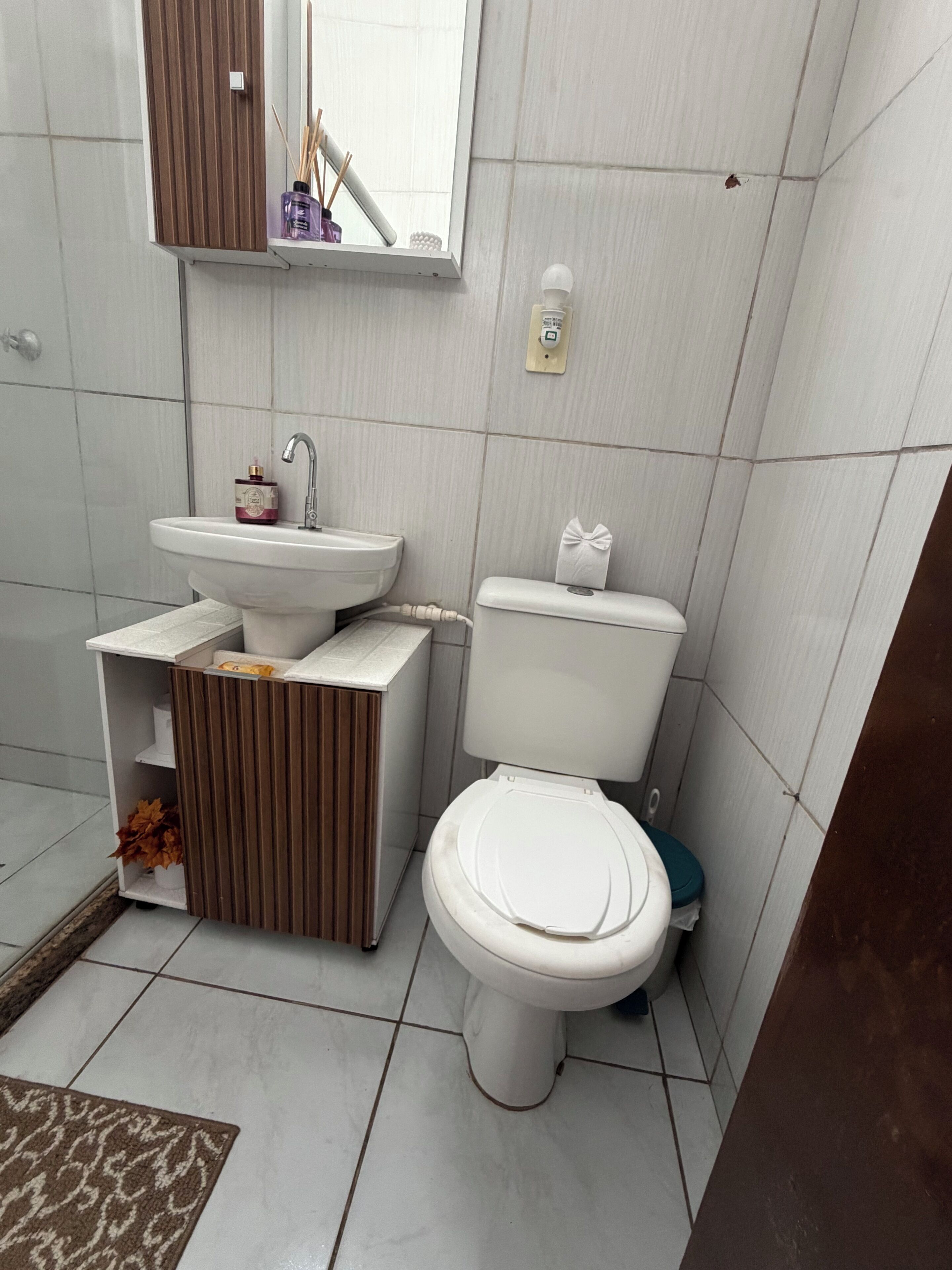 A bathroom with a toilet, sink, and mirror.