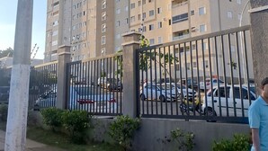 A multi-story residential building with a gated parking area.