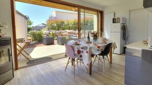 Eine moderne Küche mit Essbereich, großen Fenstern und Blick ins Freie.