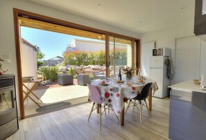 A modern kitchen with a dining area, large windows, and a view of the outdoors. - L'Atelier - SAINT VERAND (SAINT VERAND)