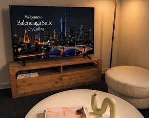 Un televisor muestra un paisaje urbano con el mensaje 'Welcome to Balenciaga Suite On Collins'.
