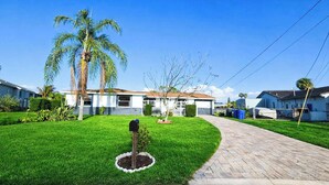 Una strada residenziale con case, una cassetta postale e un prato curato.