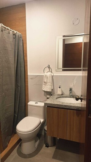 Ein Badezimmer mit Toilette, Waschbecken und Spiegel.