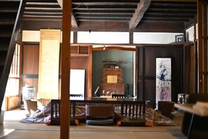 Una habitación japonesa tradicional con suelo de tatami, una mesa de madera baja y una puerta corredera.