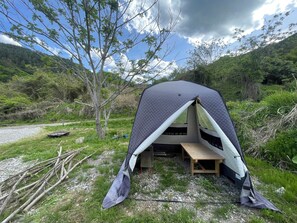 Una carpa con un interior sencillo y vistas a un paisaje natural.