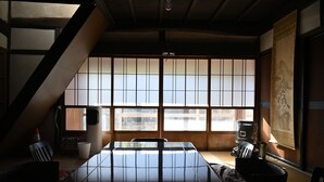 Et traditionelt japansk rum med tatamimåtter, et lavt bord, en skydedør med shoji-skærme og en ophængt rulle.