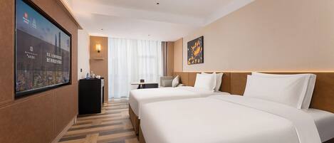 A hotel room with two beds, a desk, a chair, a TV, and a large window.