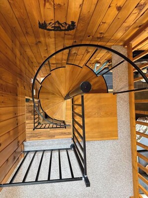 Eine Wendeltreppe mit Holzwänden und einem Metallgeländer.